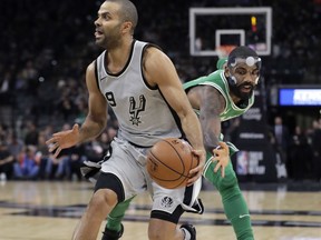 San Antonio Spurs guard Tony Parker (9) drives around Boston Celtics guard Kyrie Irving (11) during the first half of an NBA basketball game Friday, Dec. 8, 2017, in San Antonio.