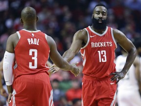 Houston Rockets guard James Harden (13) shakes hands with Chris Paul after a foul during the first half of an NBA basketball game against the Milwaukee Bucks, Saturday, Dec. 16, 2017, in Houston.