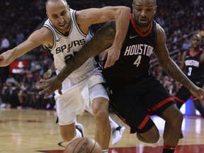 San Antonio Spurs guard Manu Ginobili, left, and Houston Rockets forward P.J. Tucker (4) battle for the ball in the first half of an NBA basketball game Friday, Dec. 15, 2017, in Houston.