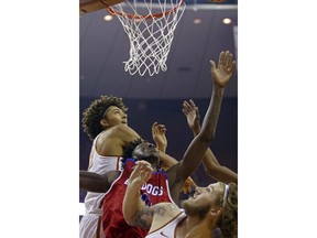 Texas forwards Jericho Sims, left, and Dylan Osetkowski, right, fight for the rebound with Louisiana Tech forward Anthony Duruji, center, during the first half of an NCAA college basketball game, Saturday, Dec. 16, 2017, in Austin, Texas.