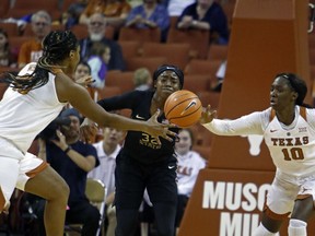 Florida State guard Imani Wright, center, fights for the ball with Texas forward Jatarie White, left, and guard Lashann Higgs, right, during the first half of an NCAA college basketball game, Sunday, Dec. 17, 2017, in Austin, Texas.
