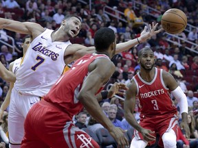 Los Angeles Lakers forward Larry Nance Jr. (7) reaches for a rebound between Houston Rockets forward Trevor Ariza (1) and guard Chris Paul (3) in the first half of an NBA basketball game, Wednesday, Dec. 20, 2017, in Houston.