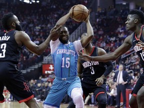 Charlotte Hornets guard Kemba Walker (15) looks to pass under pressure from Houston Rockets guard James Harden (13) guard Chris Paul (3) and center Clint Capela (15) during the first half of an NBA basketball game Wednesday, Dec. 13, 2017, in Houston.