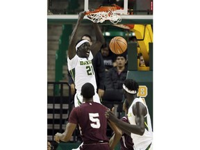 Baylor forward Nuni Omot (21) dunks as Texas Southern center Trayvon Reed (5) and Jo Lual-Acuil Jr., right, of Australia watch in the first half of an NCAA college basketball game, Thursday, Dec. 14, 2017, in Waco, Texas.