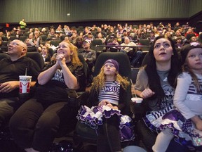 Rex Baxter, Jenn Baxter, Izzy Baxter, 9, Alexx Baxter, and Nyxx Baxter, 5, from left, alongside family and fans react after a play while watching television coverage of Weber State playing James Madison in the quarterfinals of the FCS NCAA college football playoffs, Friday, Dec. 8, 2017, in Ogden, Utah.