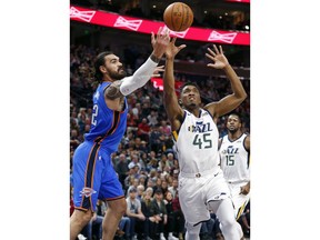 Utah Jazz guard Donovan Mitchell (45) and Oklahoma City Thunder center Steven Adams, left, battle for a rebound in the first half during an NBA basketball game Saturday, Dec. 23, 2017, in Salt Lake City.