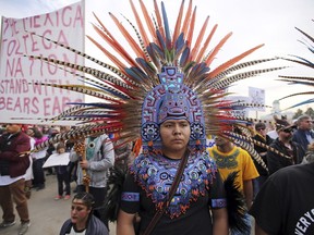 A supporter of the Bears Ears and Grand Staircase-Escalante National Monuments wears a colorful headdress during a rally Saturday, Dec. 2, 2017, in Salt Lake City. President Donald Trump is expected to announce plans next week to shrink the two sprawling Utah national monuments by reversing actions taken by former President Barack Obama.
