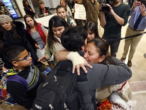 In this Monday, Dec. 25, 2017 photo, Maria Santiago Garcia, right, receives a hug before going through security gate at the Salt Lake City International Airport. Garcia, a Guatemalan woman facing deportation spent Christmas night at Salt Lake City's airport before flying back to her native country with her four young children after months of failed efforts to win her a reprieve to stay in the U.S. About 20 friends and supporters came to the airport to send the family off.