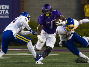 South Dakota State safety Nick Farina, left, and South Dakota State defensive end Ryan Earith (90) tackle James Madison running back Trai Sharp (1) during the first half of a FCS semifinals football game, Saturday, Dec. 16, 2017 in Harrisonburg, Va.