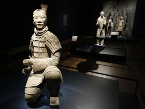 In a Tuesday, Dec. 12, 2017 photo, visitors look over some of the Terracotta Army soldiers on exhibit at the Virginia Museum of Fine Arts in Richmond, Va. The Museum has 10 of the majestic terracotta figures on display as part of an exhibit that tells the story of the first emperor of China and the time period he reigned.