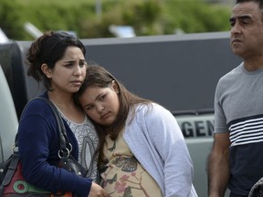 Relatives of crew members of the missing ARA San Juan submarine stand outside the navy base in Mar del Plata, Argentina, Friday, Dec. 1, 2017. Argentina has ended a rescue operation for 44 crew members aboard submarine that went missing on Nov. 15, but it will continue the search for the sub, the Navy informed Thursday, Nov. 30. (AP Photo/Marina Devo)