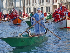 People wearing Santa Claus costumes row on Canal Grande in Venice, Italy, Sunday, Dec. 17 2017. Almost a hundred traditional rowing boats, of various kinds and sizes, for about two hundred rowers, gave life to the traditional water procession of the Santa Claus, parading along the Grand Canal.