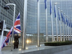 A member of protocol puts up the British flag outside EU headquarters in Brussels on Monday, Dec. 4, 2017. British Prime Minister Theresa May and EU Commission President Jean-Claude Juncker will hold a power lunch on Monday, seeking a breakthrough in the Brexit negotiations ahead of a key EU summit the week after.