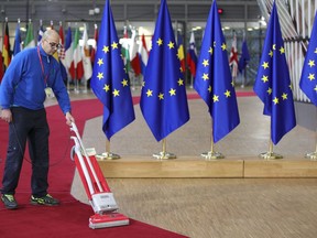 A worker vacuums the red carpet ahead of arrivals of EU leaders for an EU summit at the Europa building in Brussels on Thursday, Dec. 14, 2017. European Union leaders are gathering in Brussels and are set to move Brexit talks into a new phase as pressure mounts on Prime Minister Theresa May over her plans to take Britain out of the 28-nation bloc.