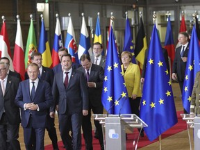 European Council President Donald Tusk, front center, and European Commission President Jean-Claude Juncker, front left, lead EU leaders to a group photo at an EU summit at the Europa building in Brussels on Thursday, Dec. 14, 2017. European Union leaders are gathering in Brussels and are set to move Brexit talks into a new phase as pressure mounts on Prime Minister Theresa May over her plans to take Britain out of the 28-nation bloc.