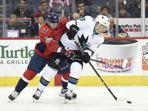 Washington Capitals defenseman Dmitry Orlov (9), of Russia, fights for the puck against San Jose Sharks right wing Timo Meier (28), of Switzerland, during the first period of an NHL hockey game, Monday, Dec. 4, 2017, in Washington.