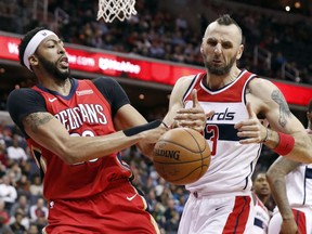 New Orleans Pelicans forward Anthony Davis (23) battles for the ball with Washington Wizards center Marcin Gortat (13), from Poland, during the first half of an NBA basketball game Tuesday, Dec. 19, 2017, in Washington.