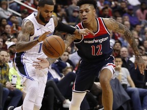 Orlando Magic guard D.J. Augustin, left, drives past Washington Wizards forward Kelly Oubre Jr., during the first half of an NBA basketball game Saturday, Dec. 23, 2017, in Washington.