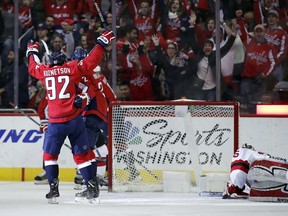 Washington Capitals center Evgeny Kuznetsov (92), from Russia, celebrates with defenseman Matt Niskanen (2) and others, after Niskanen's goal past New Jersey Devils goaltender Cory Schneider, right, in the third period of an NHL hockey game, Saturday, Dec. 30, 2017, in Washington. The Capitals 5-2.