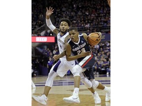 Gonzaga's Zach Norvell Jr., right, tries to drive past Washington's David Crisp in the first half of an NCAA college basketball game Sunday, Dec. 10, 2017, in Seattle.