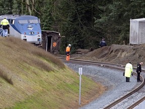 Cars from an Amtrak train remain on the tracks above where other cars spilled below onto Interstate 5 Monday, Dec. 18, 2017, in DuPont, Wash. The Amtrak train making the first-ever run along a faster new route hurtled off the overpass Monday near Tacoma and spilled some of its cars onto the highway below, killing some people, authorities said. Seventy-eight passengers and five crew members were aboard when the train moving at more than 80 mph derailed about 40 miles south of Seattle before 8 a.m., Amtrak said.