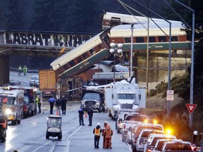 Lights illuminate cars from an Amtrak train that derailed above Interstate 5, Monday, Dec. 18, 2017, in DuPont, Wash. The Amtrak train making the first-ever run along a faster new route hurtled off the overpass Monday near Tacoma and spilled some of its cars onto the highway below, killing several people, authorities said.