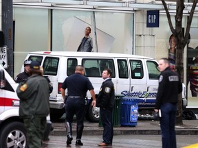 Police stand at the scene after a white van went into a downtown Seattle store on Thursday, Dec. 28, 2017.
