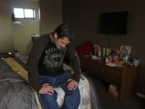 In this MON., Dec. 4, 2017 photo, Joshua Rape sits on his bed in the motel where he was living while waiting to move into an apartment paid for with a housing voucher in Everett, Wash. For years, Rape's life was a revolving door of drug use, jail stints, homeless shelters, and street-wanderings, until a specialized team of mental health professionals, housing and recovery experts, social workers and police officers worked to build a relationship with him.