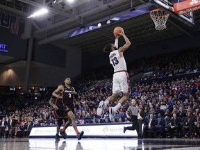 Gonzaga guard Josh Perkins (13) shoots in front of Pacific guard Miles Reynolds (3) during the first half of an NCAA college basketball game in Spokane, Wash., Thursday, Dec. 28, 2017.