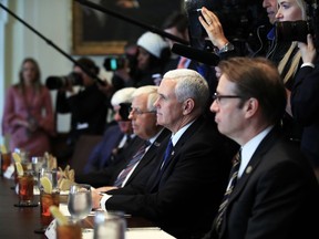 Vice President Mike Pence, flanked by Rep. Peter Roskam, R-Ill., right, and Sen. Mike Enzi, R-Wyo., third from right, listens to President Donald Trump speak during a bicameral meeting with lawmakers working on the tax cuts in the Cabinet Meeting Room of the White House in Washington, Wednesday, Dec. 13, 2017.