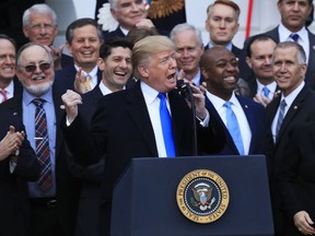 House Speaker Paul Ryan of Wis., back left center, and other lawmakers react as President Donald Trump speaks about the passage of the tax overhaul bill on the South Lawn at the White House in Washington, Wednesday, Dec. 20, 2017.