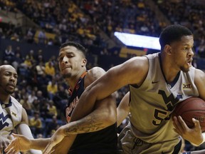 Virginia forward Isaiah Wilkins (21) West Virginia forward Sagaba Konate, right, struggle for control of a rebound during the first half of an NCAA college basketball game Tuesday Dec. 5, 2017, in Morgantown, W.Va.