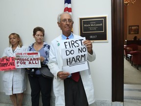 In this July 17, 2017 photo, retired family physician Jay Brock of Fredericksburg, Va., joins other protesters against the Republican health care bill outside the office of Senate Majority Leader Mitch McConnell of Ky., on Capitol Hill in Washington. A year after a big change in leadership, a survey by The Associated Press-NORC Center for Public Affairs Research finds that 48 percent named health care as a top problem for the country.