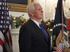 FILE - In this Dec. 6, 2017, file photo, Vice President Mike Pence listens as President Donald Trump speaks in the Diplomatic Reception Room of the White House in Washington. Pence is postponing his trip to Egypt and Israel until the middle of January, citing an upcoming vote in the Senate to overhaul the nation's tax system.