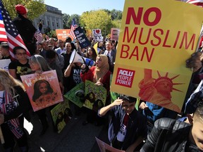 FILE - In this Oct. 18, 2017, file photo, protesters gather at a rally in Washington. The Supreme Court is allowing the Trump administration to fully enforce a ban on travel to the United States by residents of six mostly Muslim countries. The justices say in an order on Dec. 4, that the policy can take full effect even as legal challenges against it make their way through the courts.