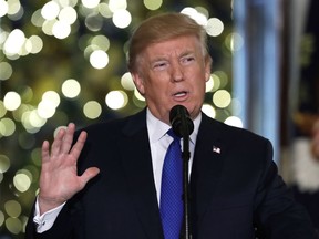 In this Dec. 13, 2017, photo, President Donald Trump speaks in the Grand Foyer of the White House in Washington. Most Americans think Trump did something either Illegal or unethical regarding his presidential campaign's ties to Russia_ and they think he's trying to obstruct the investigation looking into those connections. A new poll by the Associated Press-NORC Center for Public Affairs Research reveals a deeply divided country more concerned about health care and the economy than any collusion with the Kremlin