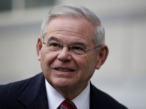 FILE - In this Nov. 16, 2017, file photo, Sen. Bob Menendez, D-N.J., answers a question from a reporter before entering the Martin Luther King Jr. Federal Courthouse in Newark, N.J. Menendez has a message for the Justice Department: Try to prosecute him again on corruption charges or drop it. Menendez, whose bribery trial ended in a hung jury last month, said Dec. 14 that he wants the charges thrown out and is seeking a decision by mid-January by government prosecutors.