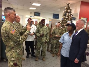 Lt. Gen. Stephen Townsend takes a photo of Defense Secretary Jim Mattis and a dining facility worker at Fort Bragg, N.C., Friday, Dec. 22, 2017.