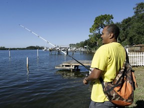 In this Nov. 30, 2017 photo, Anthony Stansbury fishes in the Anclote River in Tarpon Springs, Fla. When Stansbury moved down the street from the Anclote River in Florida last year, he didn't know his slice of paradise had a hidden problem.  The neighborhood is adjacent to the Stauffer Chemical Co. Superfund site, a former chemical manufacturing plant on the list of the nation's most polluted places.