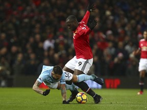 Manchester City's Nicolas Otamendi, left, fights for the ball with Manchester United's Romelu Lukaku during the English Premier League soccer match between Manchester United and Manchester City at Old Trafford Stadium in Manchester, England, Sunday, Dec. 10, 2017.