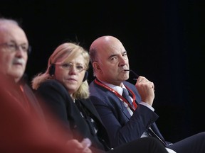 Pierre Moscovici, European Commissioner for Economic and Financial Affairs, right, listens to speakers during the Party of European Socialists Council in Lisbon, Saturday, Dec. 2 2017. At center is Corina Cretu, European Commissioner for Regional Policy.