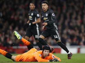 Manchester United's Jesse Lingard, right, celebrates after scoring his side's second goal past Arsenal goalkeeper Petr Cech, on the ground,during the English Premier League soccer match between Arsenal and Manchester United at the Emirates stadium in London, Saturday, Dec. 2, 2017.