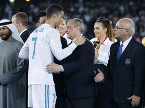 Real Madrid's Cristiano Ronaldo greets Real Madrid President Florentino Perez, center, and Gremio President Romildo Bolzan Jr., right, after winning the Club World Cup final soccer match between Real Madrid and Gremio at Zayed Sports City stadium in Abu Dhabi, United Arab Emirates, Saturday, Dec. 16, 2017.