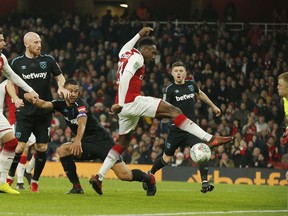 Arsenal's Danny Welbeck, centre, scores the opening goal of the game during the English League Cup quarterfinal soccer match between Arsenal and West Ham United at the Emirates stadium in London, Tuesday, Dec. 19, 2017.