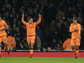 Liverpool's Philippe Coutinho, second left, celebrates after he scoreD the opening goal of the game during their English Premier League soccer match between Arsenal and Liverpool at the Emirates stadium London, Friday, Dec. 22, 2017.