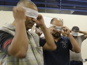 In this Nov. 28, 2017 photo, residents of the low-income Capao Redondo neighborhood and members of the Acredito movement are blindfolded as part of a team-building exercise at a meeting to exchange ideas about the community's needs in Sao Paulo, Brazil. A handful of new organizations like Acredito are trying to reinvigorate the country's democracy by luring fresh faces into a political establishment widely seen as closed off and unrepresentative.