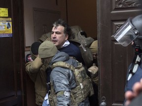 The Ukrainian Security Service officers detain Mikheil Saakashvili at the entrance of his house in Kiev, Ukraine, Tuesday, Dec. 5, 2017. Ukraine's intelligence agency on Tuesday detained the former president of Georgia who has emerged as an anti-corruption campaigner in his new country but faced an angry backlash of protesters who would not let the officers to take him away.