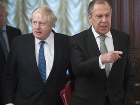 Russian Foreign Minister Sergey Lavrov, right, and British Foreign Secretary Boris Johnson enter a hall for their talks in Moscow, Russia, Friday, Dec. 22, 2017. Johnson is the first British foreign secretary to visit Moscow in more than five years, reflecting a bitter strain in bilateral ties.