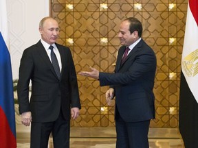 Egyptian President Abdel-Fattah El-Sissi, right, welcomes Russian President Vladimir Putin for the talks during their meeting in Cairo, Egypt, Monday, Dec. 11, 2017.