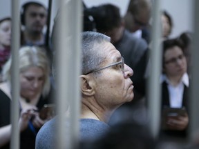 Former Russian Economic Development Minister Alexei Ulyukayev, center, waits for the hearing at a court in Moscow, Russia, Friday, Dec. 15, 2017. A Moscow court is expected to deliver a verdict in the case of former Economic Development Minister Alexei Ulyukayev who is on trial for accepting a $2 million bribe from a close ally of President Vladimir Putin.